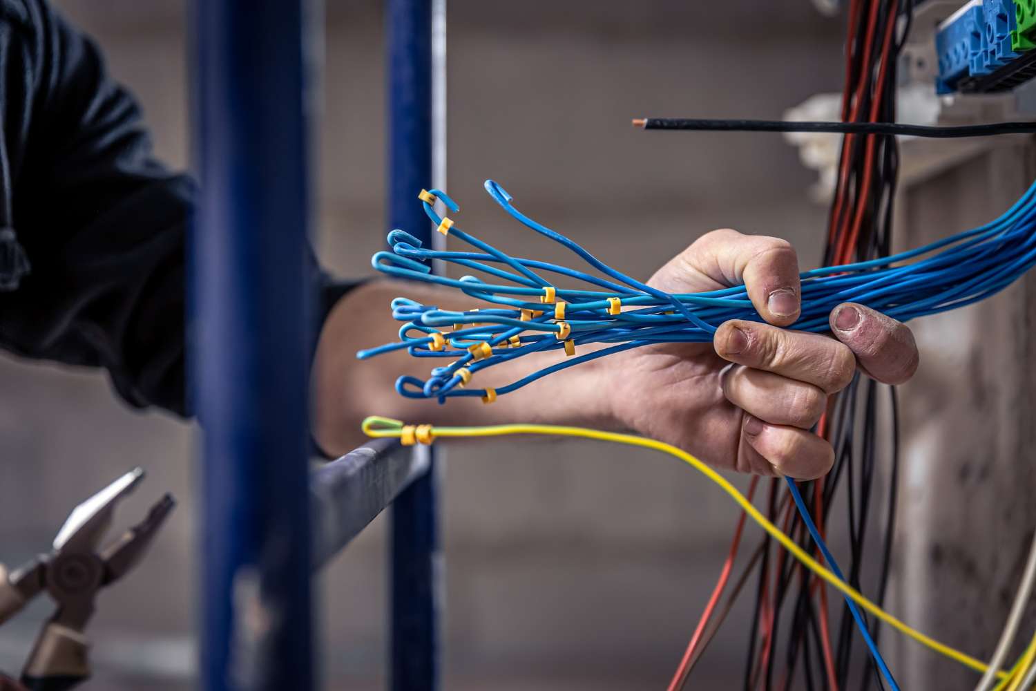male electrician works switchboard with